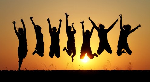 silhouette of friends jumping in sunset
